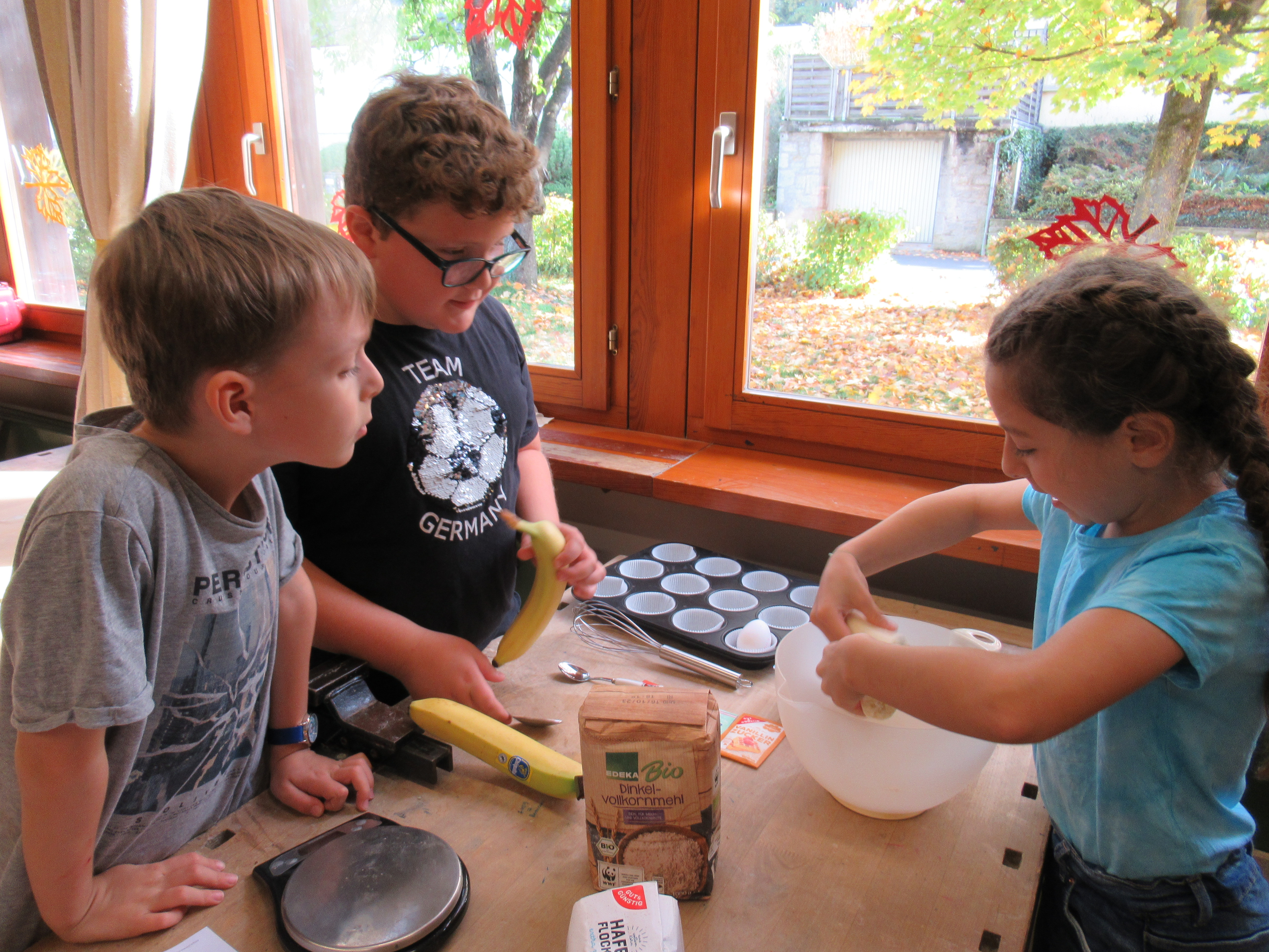 Kinder beim Zubereiten der Muffins