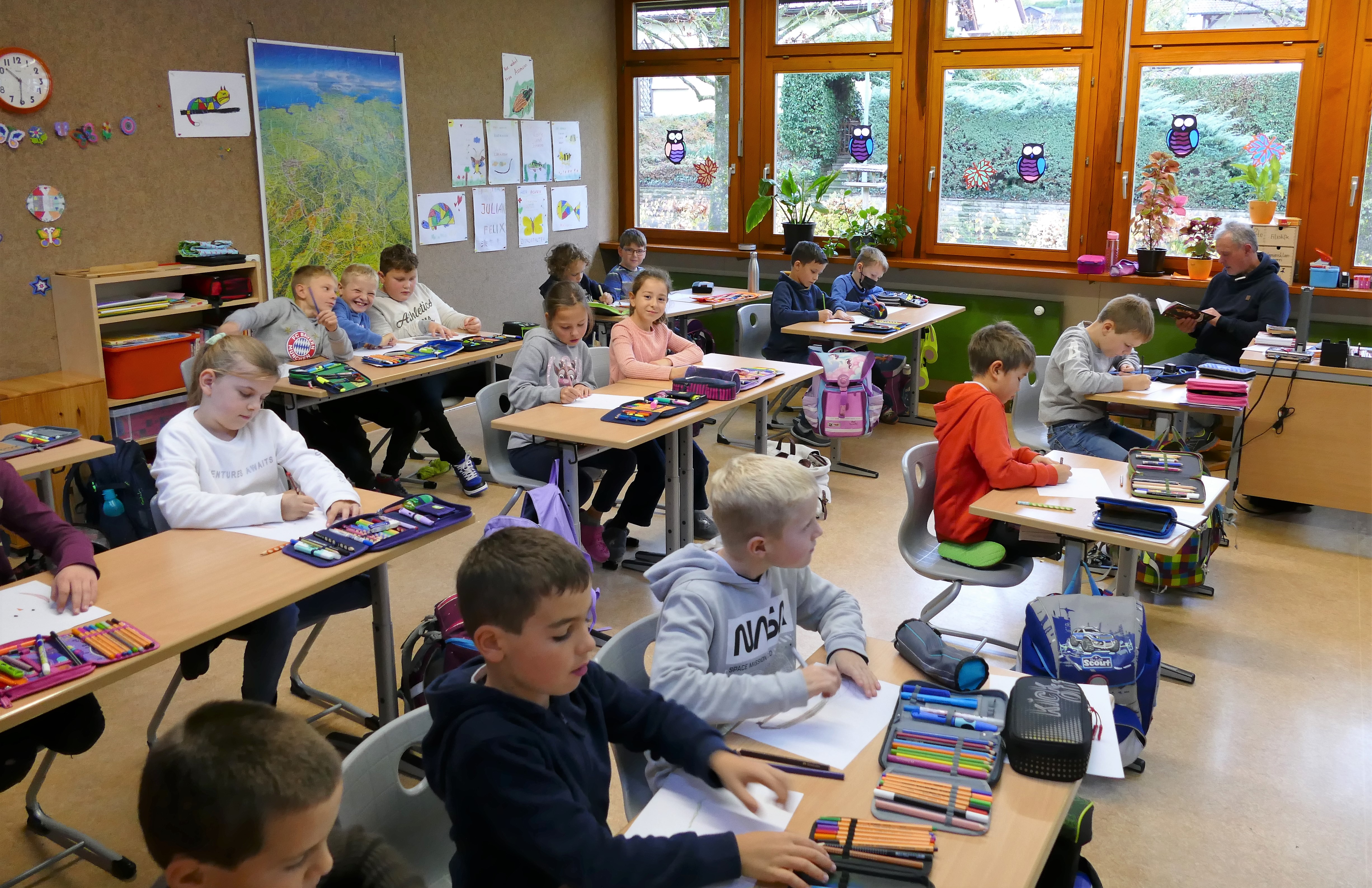 Kinder arbeiten im Klassenzimmer an ihren Tischen